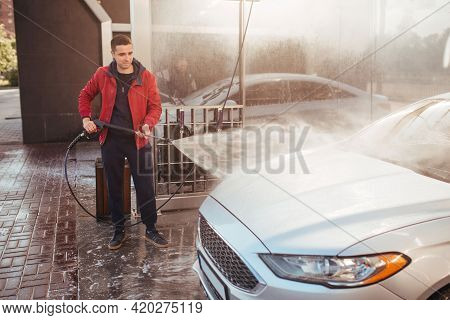 A Man Washes A Car With A Pistol At A Self-service Car Wash