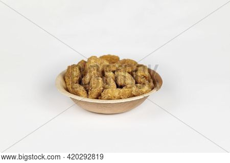 Jaggery Coated Banana Chips Or Sharkara Varatti In An Areca Leaf Bowl On A White Background