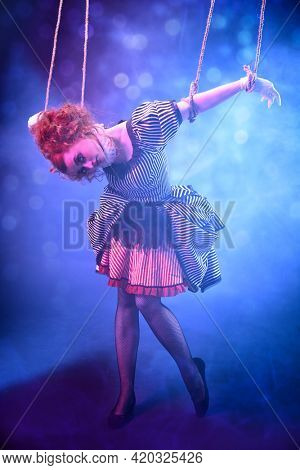 Puppet theater and circus. The actress plays a doll on strings at a performance in a puppet theater. Full length portrait in vintage style.