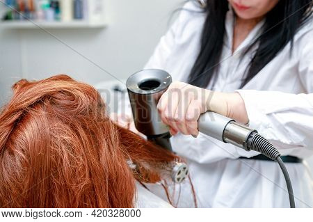 Stylist Dries Girls Hair With A Round Brush