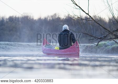 Young Man Rowing Canoe In Early Spring Morning. Lifestyle. Morning Landscape, Fog By The Morning Riv