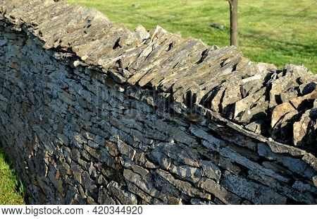 Stone Wall Laid Dry Without The Use Of Cement. The Stones Are Beige-yellow Marl. Stacked On Top Of E