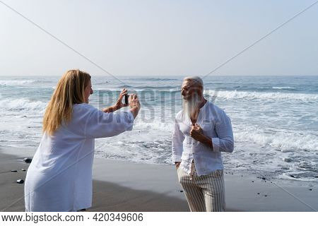 Lifestyle Of Caucasian Senior Couple Shooting Photos On Beach, Happy In Love Romantic And Relax Time