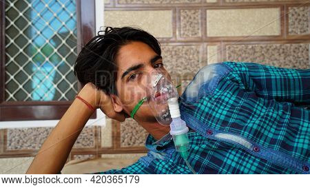 Young Boy Infected With Covid 19 Disease. Patient Inhaling Oxygen Wearing Mask With Liquid Oxygen Fl
