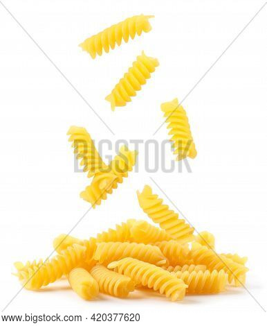 Spiral Pasta Falling On A Heap Close-up On A White Background. Isolated