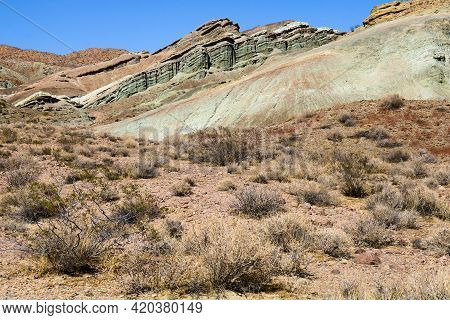 Sage Plants And The Creosote Bush On An Arid Sandy Plateau Including Hills Embedded With Colorful Ro