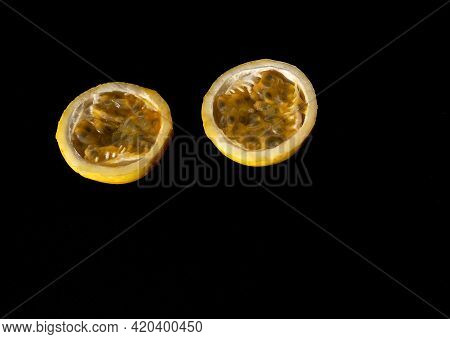 Yellow Passion Fruit With Cut In Half On Black And Yellow Background.
