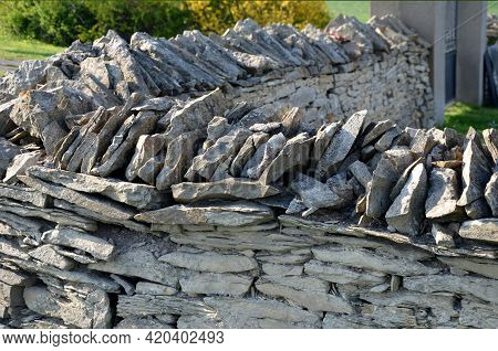 Stone Wall Laid Dry Without The Use Of Cement. The Stones Are Beige-yellow Marl. Stacked On Top Of E