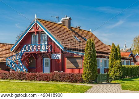 Nida, Lithuania - May 10 2021: Beautiful Old Lithuanian Traditional Wooden Red House Of The Curonian