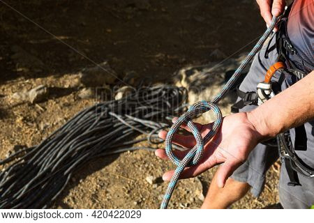 A Male Climber Ties A Safety Knot Eight On The Harness Before Climbing The Track. Climbing Equipment