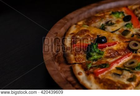 Crop And High Angle View Of Picante Pizza On Black Surface