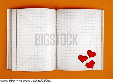 Empty Opened Notepad With Red Hearts On The Orange Paper Background Closeu