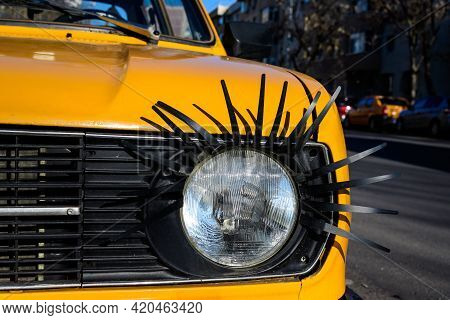 Details Of An Light From An Old Yellow Car Decorated On Street In Bucharest, Romania