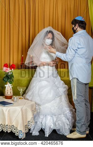 During The Chupa Ceremony In The Synagogue, The Masked Bride And Groom Cover The Bride With A Veil I