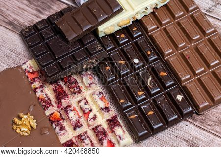 Different Kinds Fof Chocolate Bars On Vintage Wooden Background. Dark One, Milk And White, With Piec