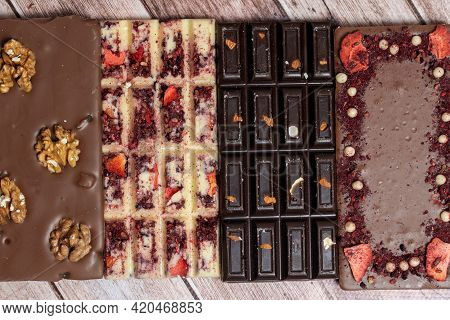 Different Kinds Fof Chocolate Bars Laying In A Row On Vintage Wooden Background. Dark One, Milk And 