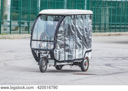 Moto-rickshaw With Passengers Moves On The City Street.