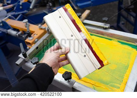 Squeegee For Serigraphy Silk Screen Print Process In Hand At Clothes Factory. Frame, Squeegee And Pl