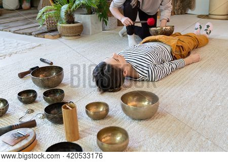 Singing Bowls Massage At Home: Two Women Practice Tibet Sound Therapy Together Using Vibrations And 