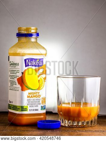 Open bottle with Mighty Mabgo drink from Naked on wooden table
