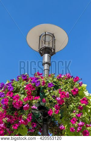 Street Lamp With Flower Decoration Against Blue Sky In The City Meiningen, Thuringia