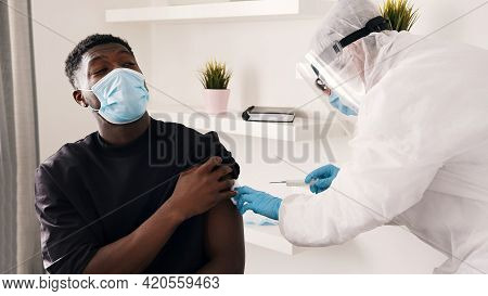 Covid-19 Or Coronavirus Vaccine. Vaccinating Citizens. Doctor Holding A Syringe And Wearing A Face A
