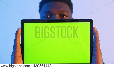 Man Showing A Tablet With A Green Screen At The Camera - Hand Gestures. High Quality Photo
