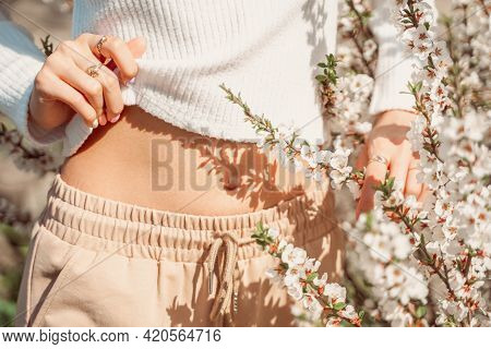 Partial View Of Beautiful Slender Woman In Delicate Clothes Posing With Hands Near Her Belly And Wit