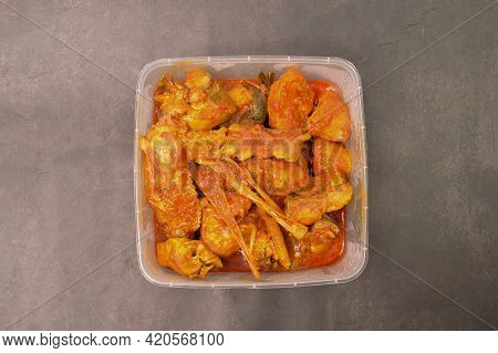 Hot Spicy Chicken In A Plastic Box Over Black Background