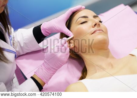 Doctor Painting The Area Of A Womans Face Where The Pdo Suture Treatment Threads Will Be Injected.