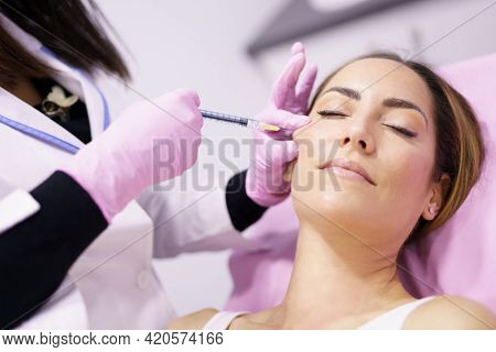 Doctor Injecting Hyaluronic Acid Into The Cheekbones Of A Woman As A Facial Rejuvenation Treatment.