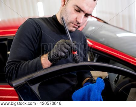 Car Service Worker Cleans Interiror With Special Brush