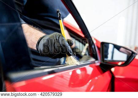 Car Service Worker Cleans Interiror With Special Brush