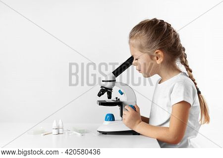Child Looking Through Microscope On White Background. Kid Scientist Learning Biology.