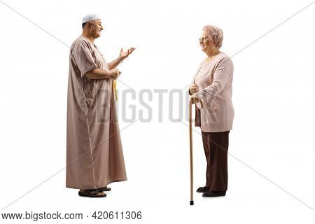 Full length profile shot of a mature muslim man talking to an elderly woman with a walking cane isolated on white background