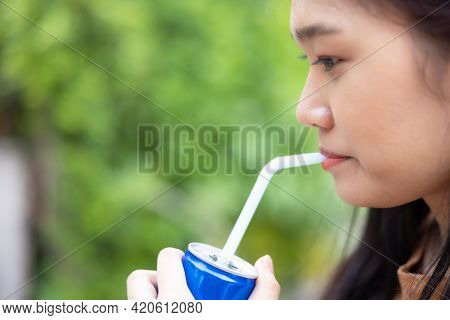 Girl Drinking A Drink Through A Straw From A Can