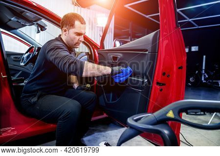 Car Service Worker Cleans Interiror With Special Brush