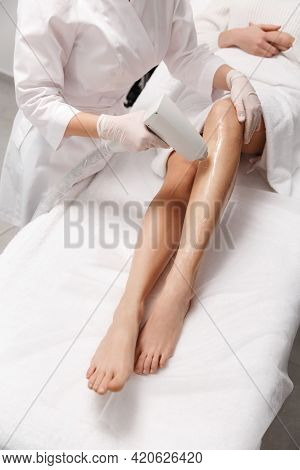 Depilation And Beauty Spa Clinic Concept. Close Up Of Women Legs Getting Laser Hair Removal Treatmen