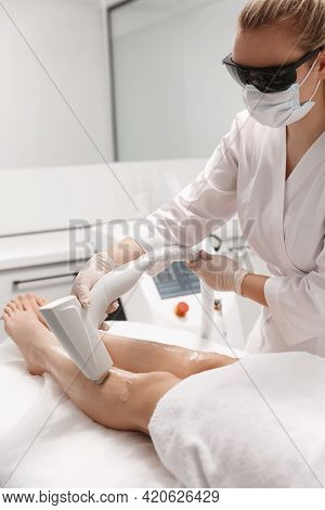 Vertical Shot Of Beautician Depilation Master Using Laser For Legs Hair Removal Procedure At Beauty 