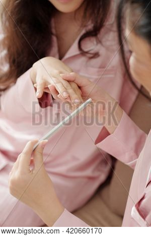 Hands Of Woman Filing Nails Of Her Friend When They Are Spending Time Together At Home