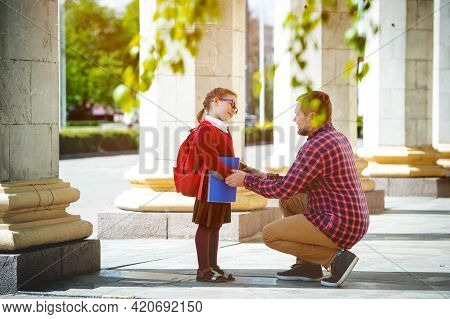 Back To School. Happy Father And Daughter Go To Elementary School. Parent Taking Child To Primary Sc