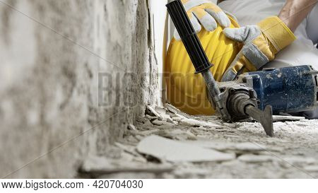 House Renovation Concept, Construction Worker Holds In Hands Helmet, Close Up With Jackhammer And Wa