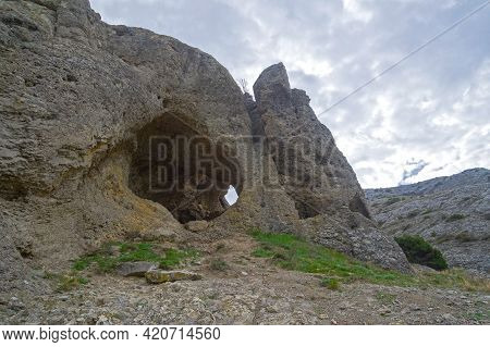 A Small Pass-through Grotto In The Rock. Cape Alchak, Sudak, Crimea. Cloud Day In April.