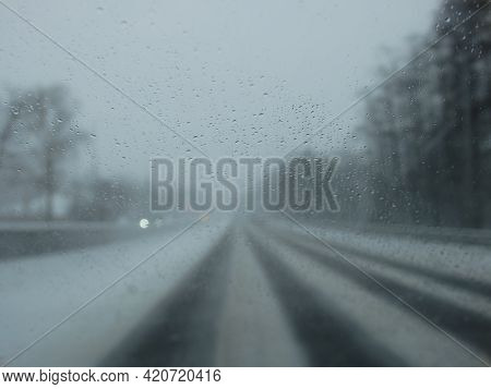 Driving In A Snow Storm. Poor Visibility Through The Driver's Glass Onto The Road Covered With Snow 