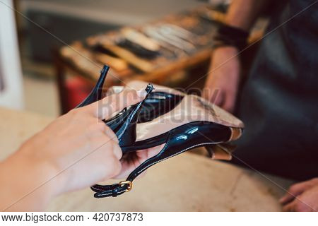 Customer bringing shoes to the shoemaker for a repair
