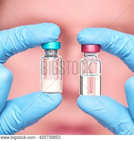 Male Person In Blue Glove Hold Vaccine Bottles. Injection Drug Pharmacy Concept. Medical Nurse Thera