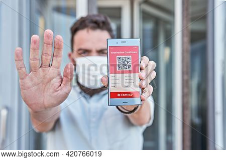Man Holding Smartphone Displaying On App Mobile Expired Digital Vaccination Certificate For Covid-19