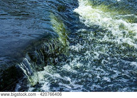 The Texture Of Water On The Surface Of A Small Waterfall In The Ukrainian Steppe Close-up. Tokovsky