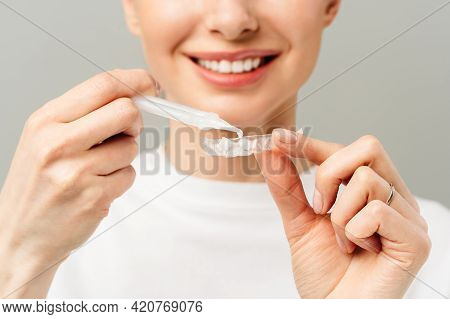 A Young Woman Does A Home Teeth Whitening Procedure. Whitening Tray With Gel
