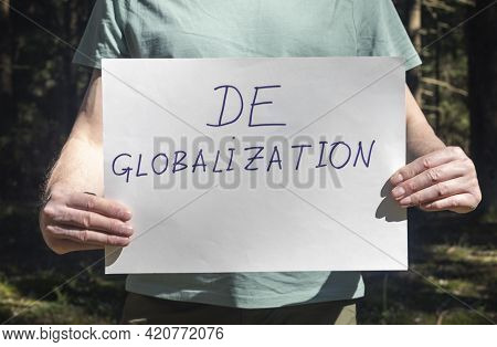 Deglobalization And Reverse Globalization Concept. Word On Paper Placard In Male Hand.